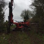 Fifteen feet long telegraph pole for a gate post being driven in to hang a gate on at Poulshot